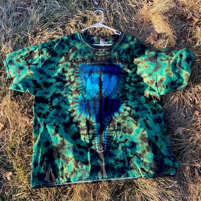 Vibrant teal, black, and blue tie-dye t-shirt with a detailed central abstract alien face design.