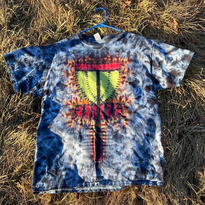 Tie-dye t-shirt in shades of blue and gray with a central red, yellow, and green disc golf basket design.