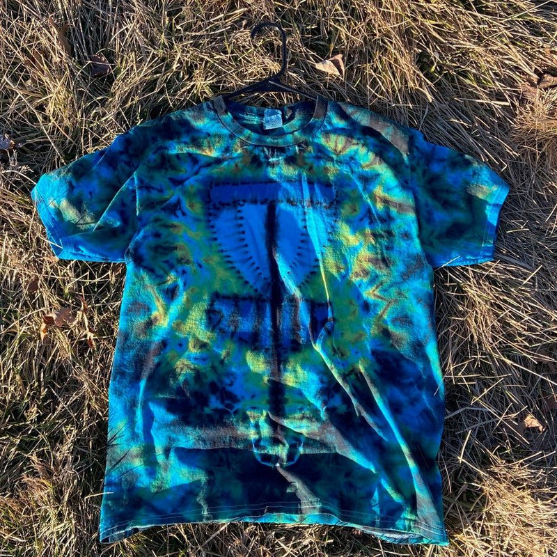 Bright blue and lime green tie-dye t-shirt with a central mushroom cap design and dark black accents.
