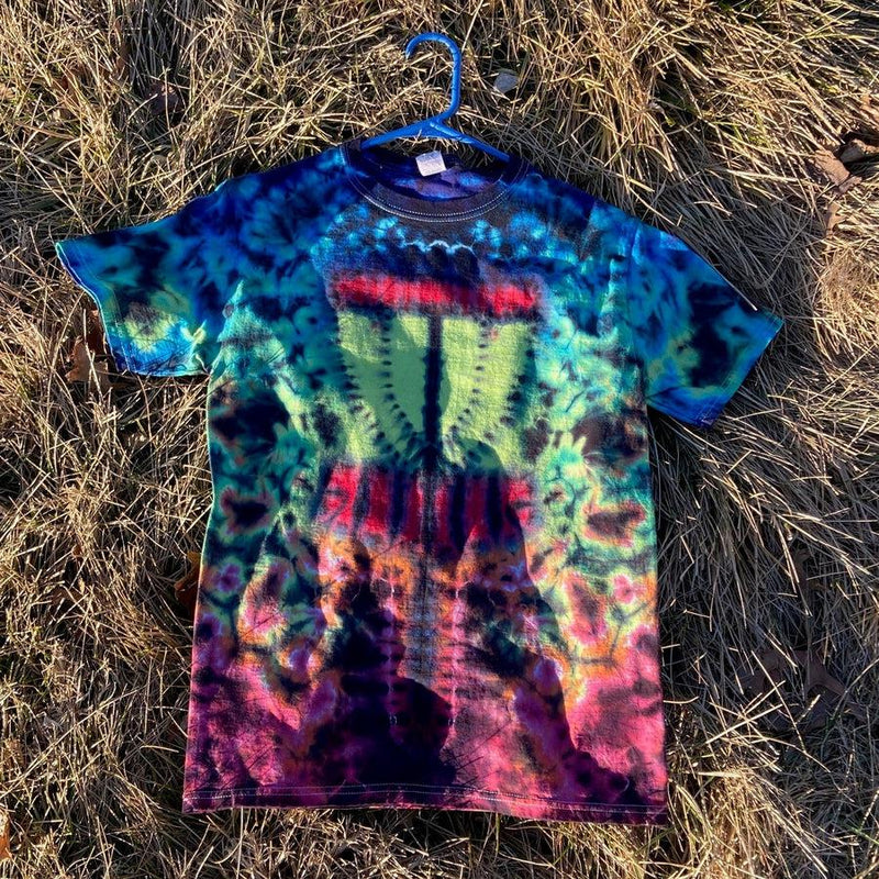 Vibrantly tie-dyed disc golf basket t-shirt in hues of blue, green, red, and purple on a blue plastic hanger.