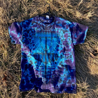 Tie-dyed t-shirt in vibrant blues, deep purples, and black with a unique twisted amanita basket style design.