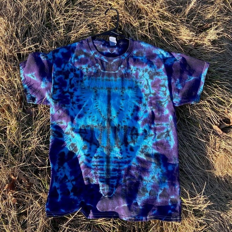Tie-dyed t-shirt in vibrant blues, deep purples, and black with a unique twisted amanita basket style design.