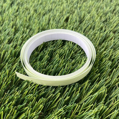 Rolled spool of dzdiscs half-inch wide glow tape, featuring a pale yellow tape strip and white adhesive backing.