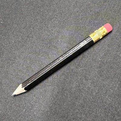 A black score-keeping disc golf pencil with a sharpened lead tip and a brass-banded pink eraser.