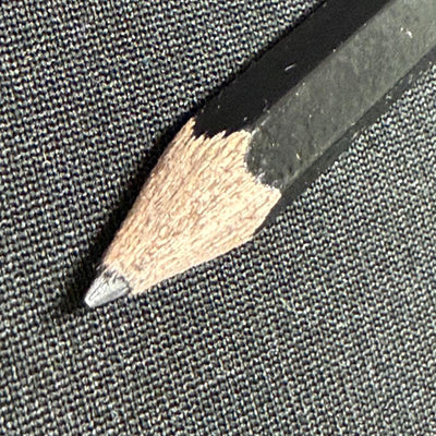 Black DZDiscs score-keeping pencil with a sharpened lead tip and natural wood exposed near the point.