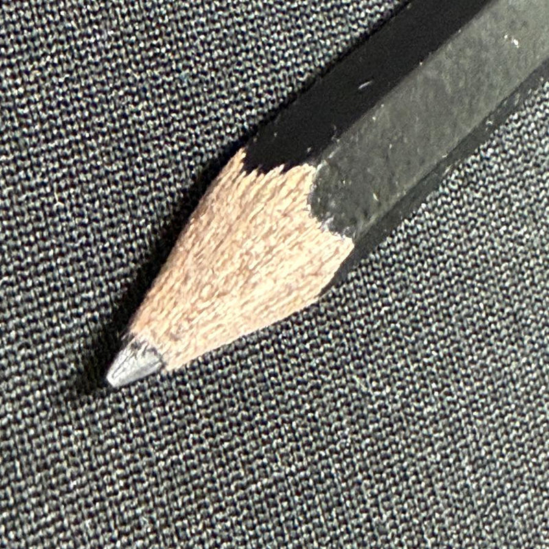 Black DZDiscs score-keeping pencil with a sharpened lead tip and natural wood exposed near the point.