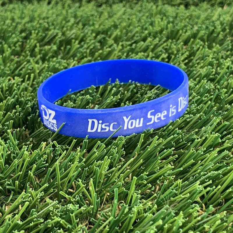 Bright blue silicone wristband from DZ Discs with white text that reads "Disc You See Is Disc".