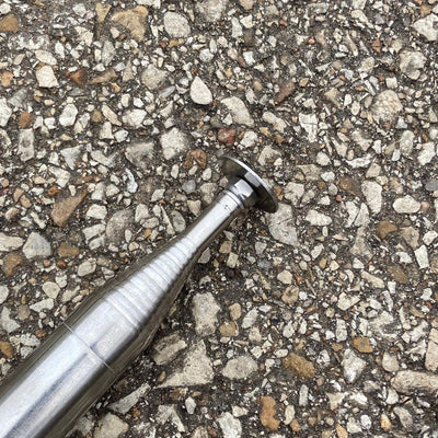 A silver metallic DZ Discs Hans Retriever tip shown at an angle, featuring ribbed sections and a flat-headed end.