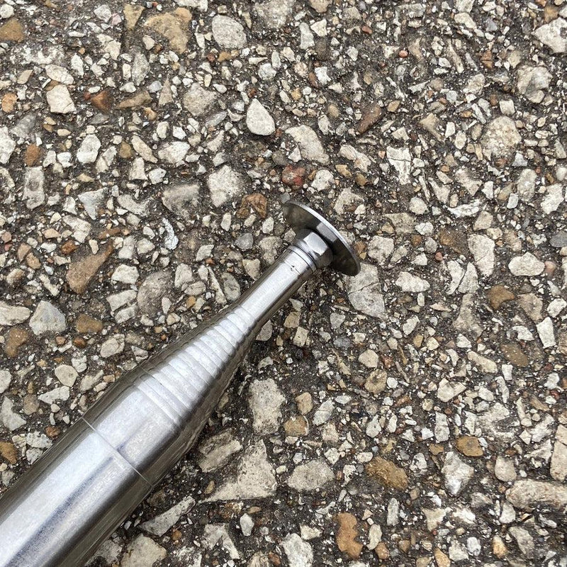 A silver metallic DZ Discs Hans Retriever tip shown at an angle, featuring ribbed sections and a flat-headed end.