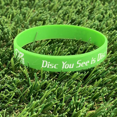 A vibrant lime green silicone wristband with white text reading "The Only Disc You See is Disc" and a small logo.