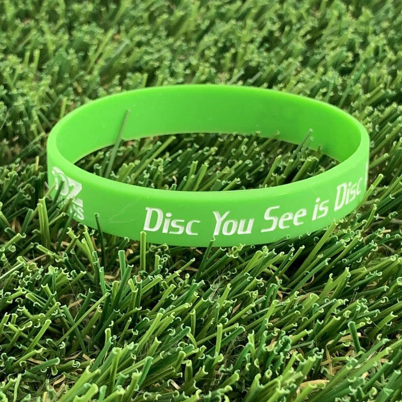 A vibrant lime green silicone wristband with white text reading "The Only Disc You See is Disc" and a small logo.