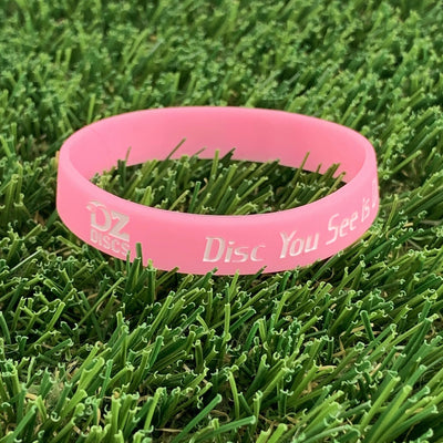 Pink silicone wristband with "OZ DISCS" and "Disc You See Is" debossed in white lettering.