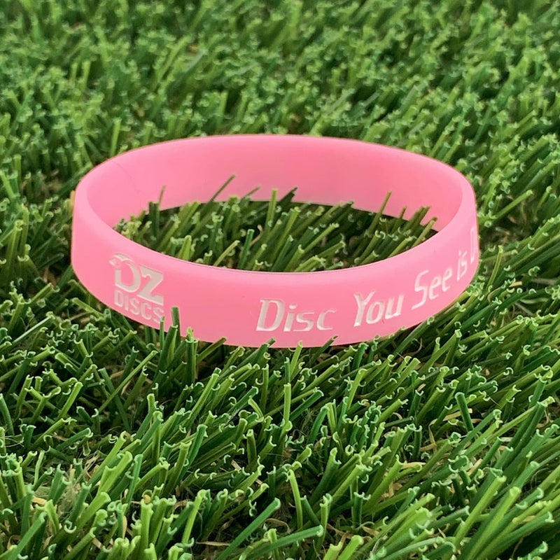 Pink silicone wristband with "OZ DISCS" and "Disc You See Is" debossed in white lettering.