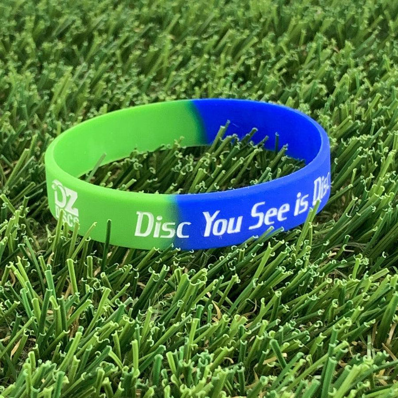 Two-tone silicone wristband in bright green and royal blue, featuring "DZDISCS" and "The Disc You See is Discraft".
