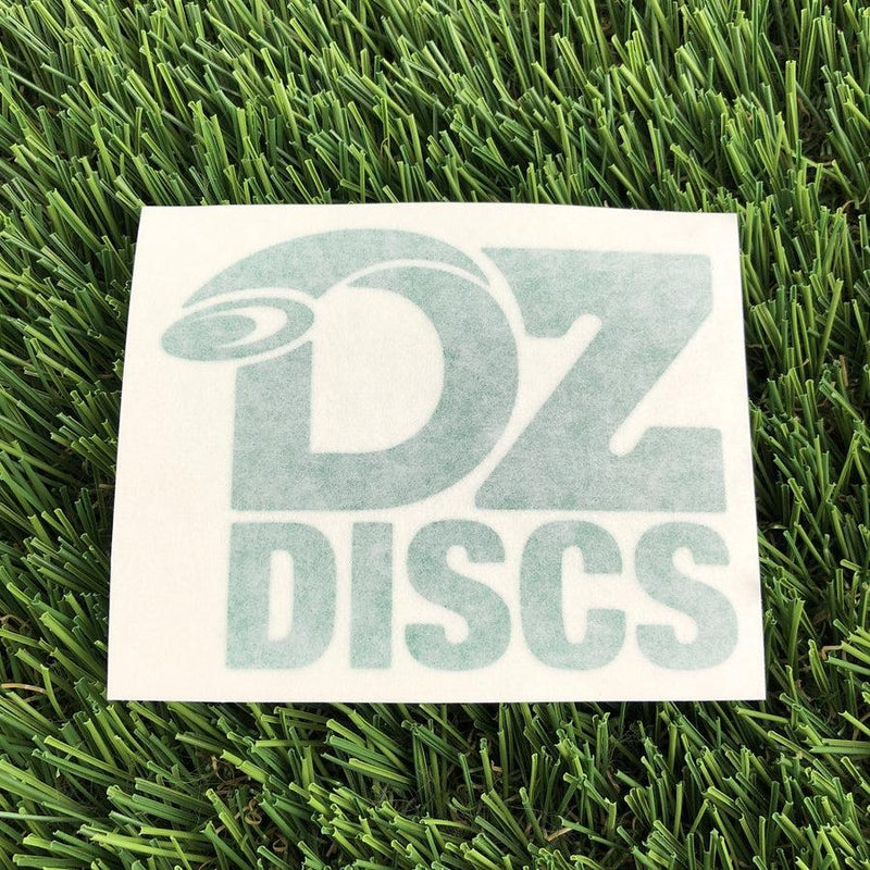 White rectangular DZ Discs vinyl decal displaying the disc golf brand name in faded teal lettering.