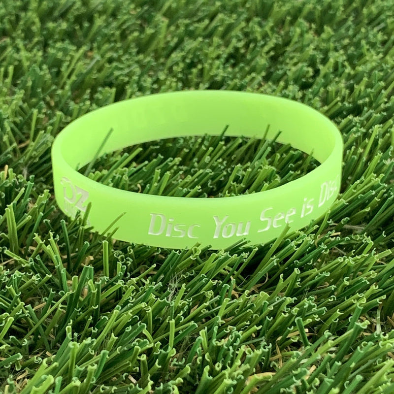 Fluorescent green silicone DZ Discs wristband with embossed white text reading "Disc You See is Disc".