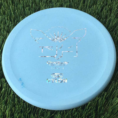 Light blue Gateway Superglow Devil Hawk golf disc with a reflective foil stamp and some blue scuff marks.