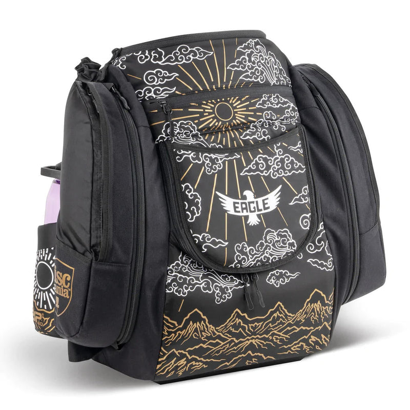 Black GRIP EQ AX5 Valhalla disc golf bag with a gold and white eagle, sun, clouds, and mountain design.