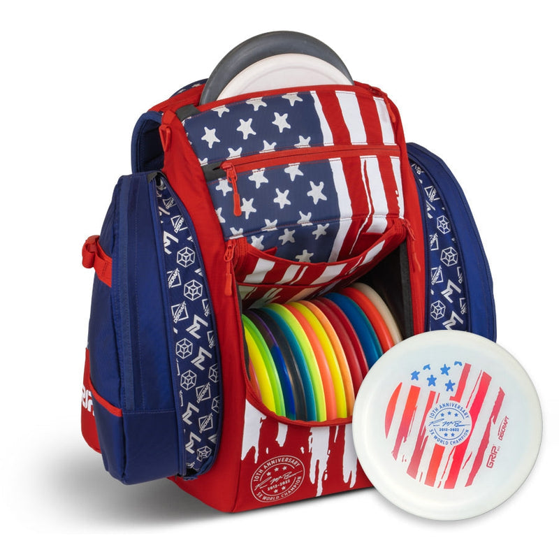Red, white, and blue GRIP EQ BX3 Series Tour Bag with multiple colorful Disc Golf discs and side pockets.