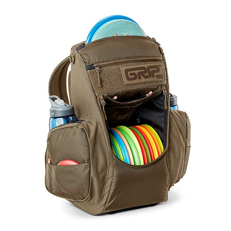 Olive green GRIP EQ CS2 disc golf backpack with numerous colored discs, water bottles, and zippered pockets.