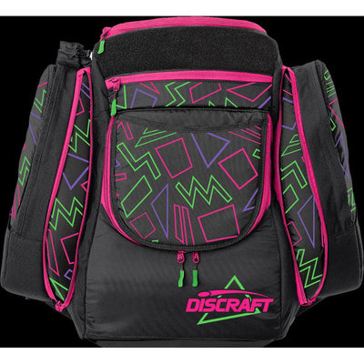 Black Grip EQ Discraft AX5 disc golf bag with pink, green, and purple geometric patterns and a neon green Discraft logo.