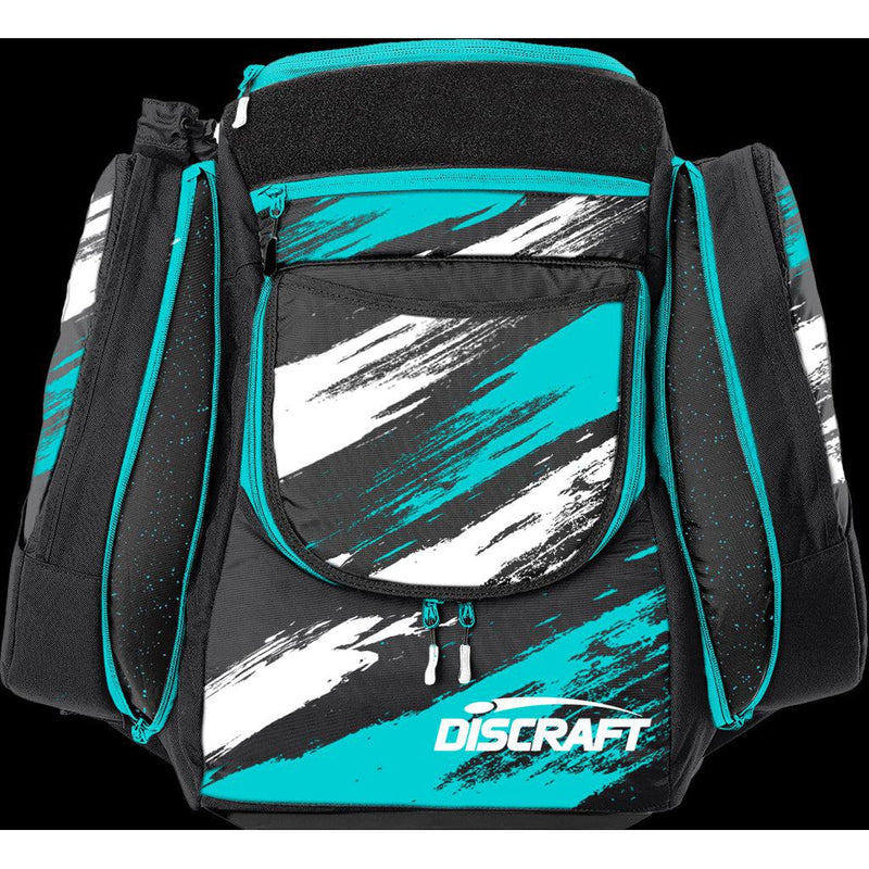 Black GRIP EQ Discraft AX5 disc golf bag with a vivid teal and white paint splash design and teal zippers.