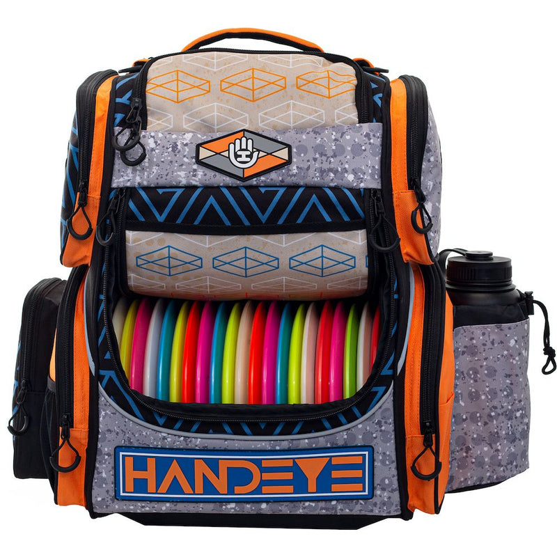 Handeye Mission Rig backpack in gray, orange, and blue with a main compartment filled with colorful disc golf discs.