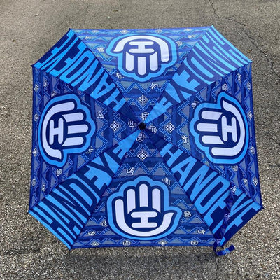 Handeye Supply Co Arc Umbrella in dark blue with light blue hand logos and text patterns across its surface.