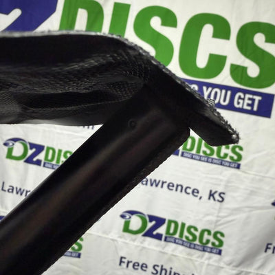 Black Huk Lab tripod stool showing a textured fabric seat attached to a smooth metal leg with visible stitching.