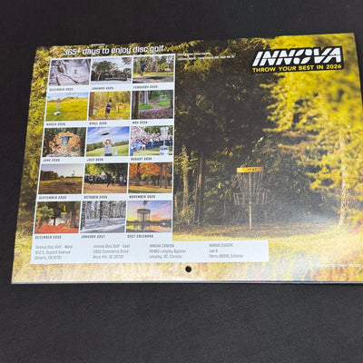 An Innova 2026 disc golf wall calendar features a yellow basket in a wooded area and 14 smaller monthly snapshots.