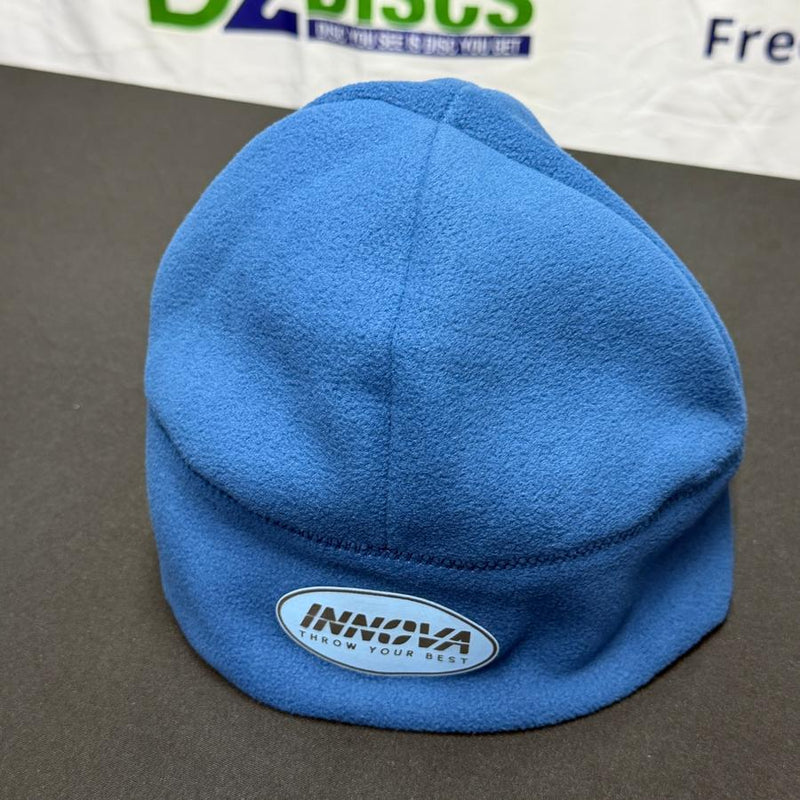 Blue fleece beanie with an oval Innova "Throw Your Best" patch stitched on the front right side.