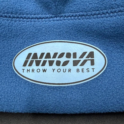 Blue fleece beanie with an oval Innova logo patch that says "THROW YOUR BEST" in black text.