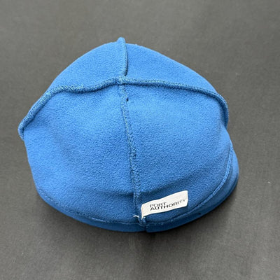 Vibrant blue fleece beanie with visible stitching and a white Port Authority tag on the back edge.