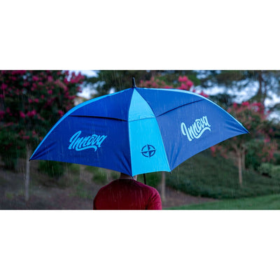 Two-toned Innova Flow Umbrella, featuring light blue and darker blue panels with Innova logos, protecting from rain.
