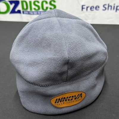 Gray Innova fleece beanie with a stitched leatherette patch displaying "Innova Throw Your Best".