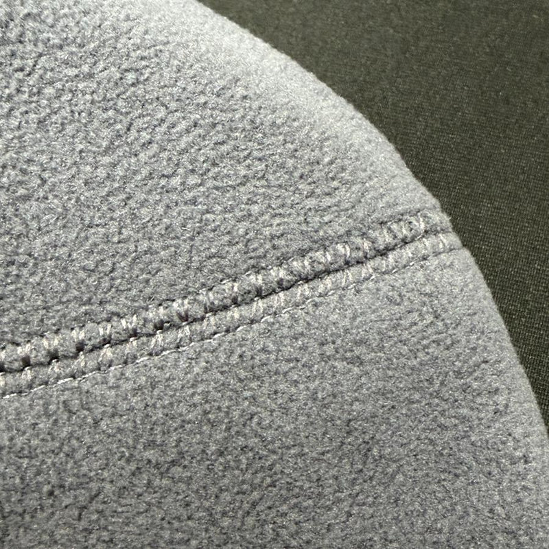 Close-up of a grey Innova fleece beanie with visible stitching on a seam, showing the texture of the material.
