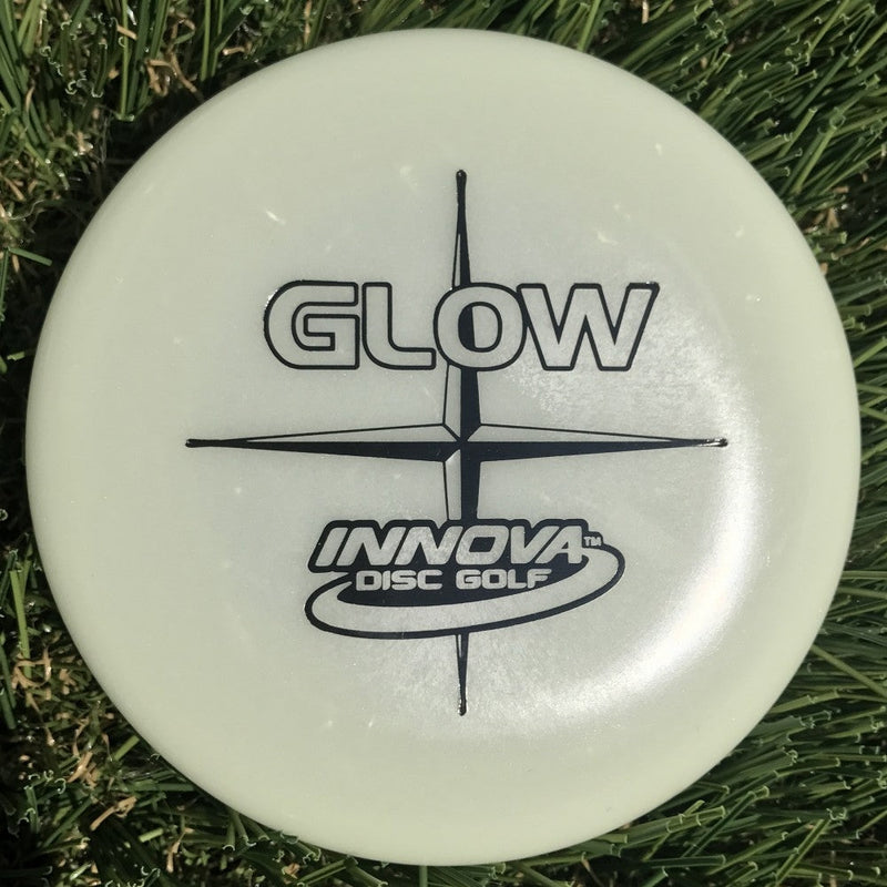 Light green Innova Glow mini disc golf marker with black "GLOW" and "Innova Disc Golf" stamping.