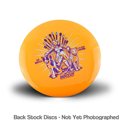 Orange Innova Metal Flake Star Leopard3 disc golf disc with a purple and light blue Kat Mertsch rockstar graphic.