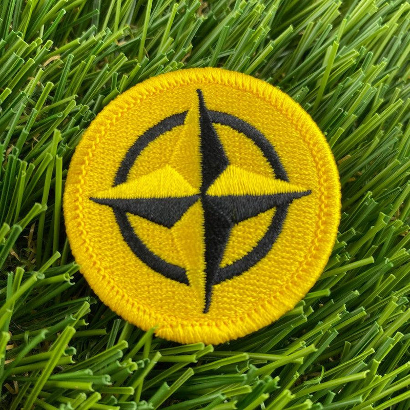 Innova Prime Star Circle yellow and black embroidered patch with a bold star compass design.