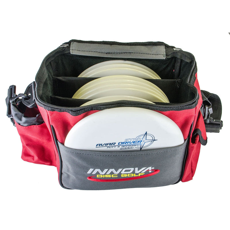 Red and dark gray Innova disc golf bag with three light yellow discs and one white Aviar Driver disc.