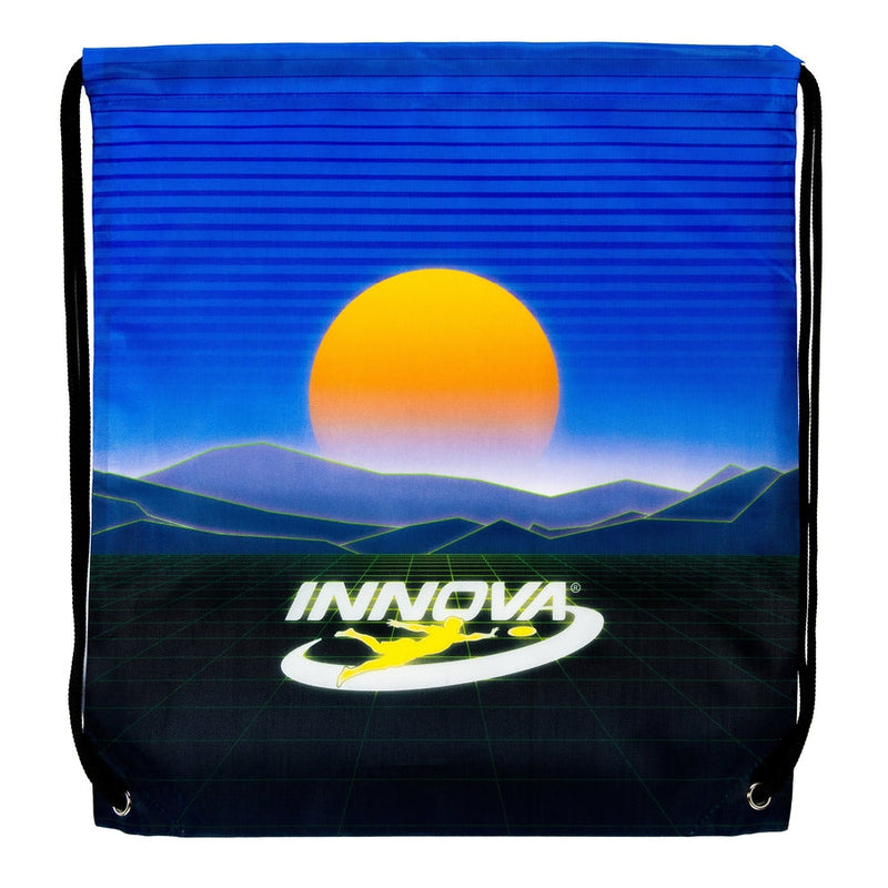 Blue Innova drawstring bag with a retro sunset desert graphic and a white Innova logo with a yellow disc golf player.