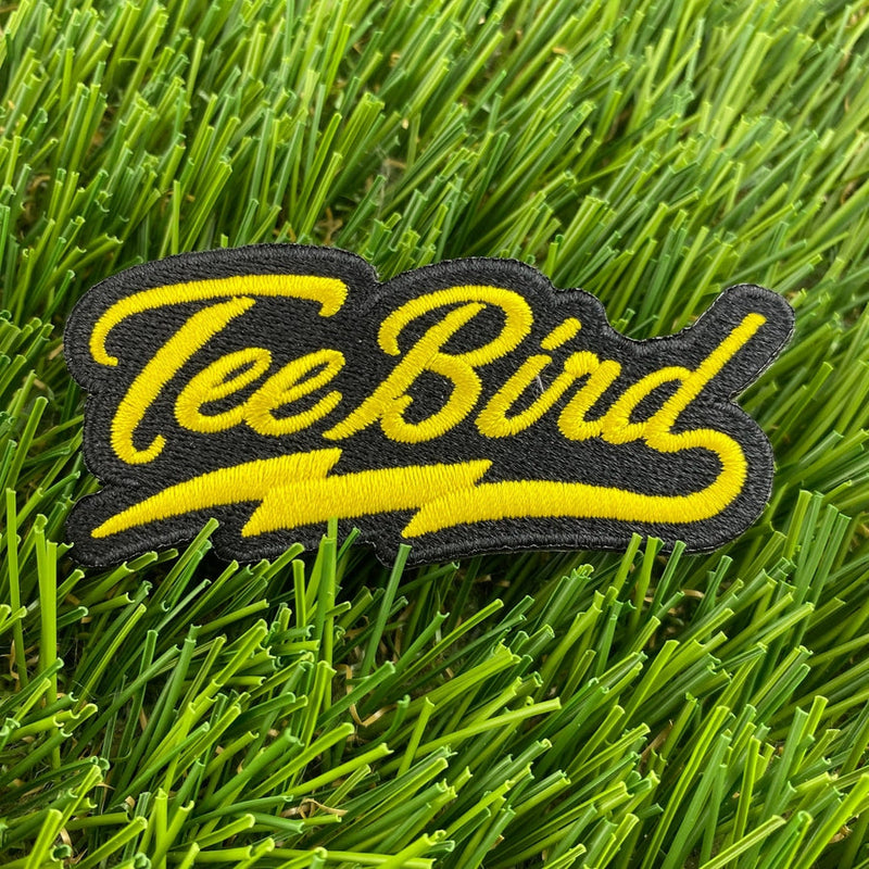 Black Innova "TeeBird" wordmark patch with bright yellow embroidered lettering and lightning bolt accents.