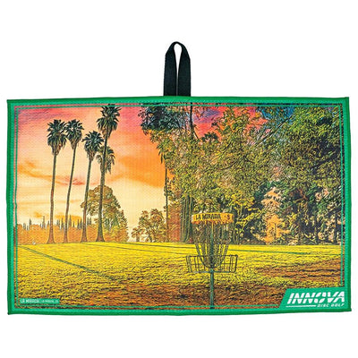 Green Innova Tour Towel La Mirada with a colorful disc golf course graphic and black hanging loop.