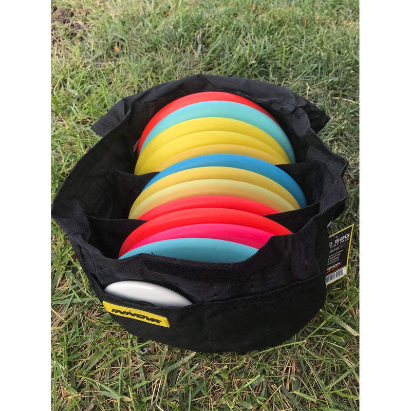 Black Innova Weekender Bag with a yellow logo, filled with vibrant red, pink, blue, and yellow disc golf discs.