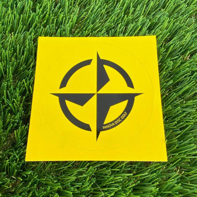 Yellow Innova Prime Star mini disc golf marker with a black four-point star design and circle.