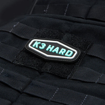 Collector's Kastaplast K3 Hard PVC patch featuring molded turquoise letters on a black background with a white border.