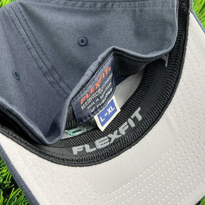 Dark navy blue FLEXFIT Kastaplast L-XL hat with a gray brim underside and black brand details.