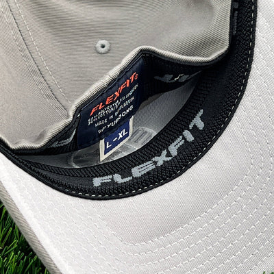 Light gray Kastaplast Flexfit clothback hat shows the interior headband and small black label with "L-XL" sizing.