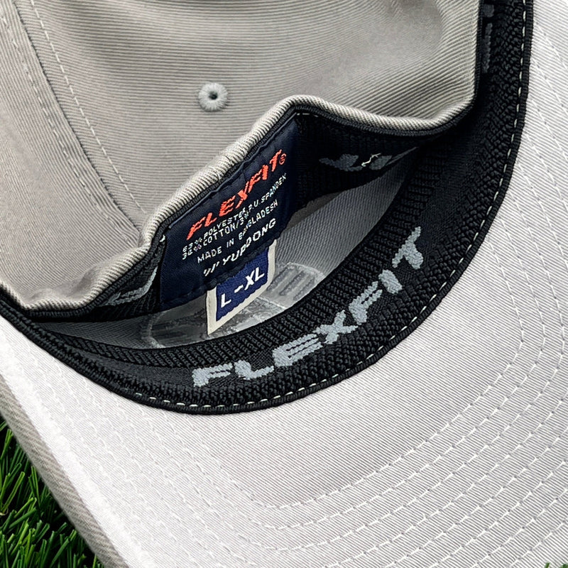 Light gray Kastaplast Flexfit clothback hat shows the interior headband and small black label with "L-XL" sizing.