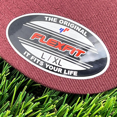 Dark red maroon fabric detail of a Flexfit LXL hat with the "It Fits Your Life" slogan.